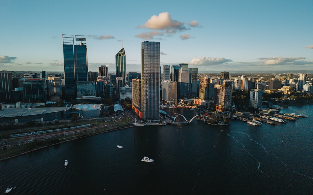 Modern cityscape with skyscrapers and a river at sunset